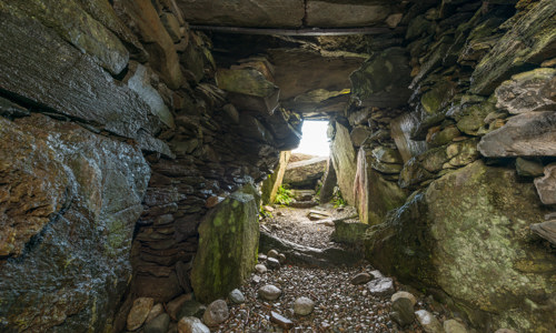 A low stone passage leading out of a cairn.